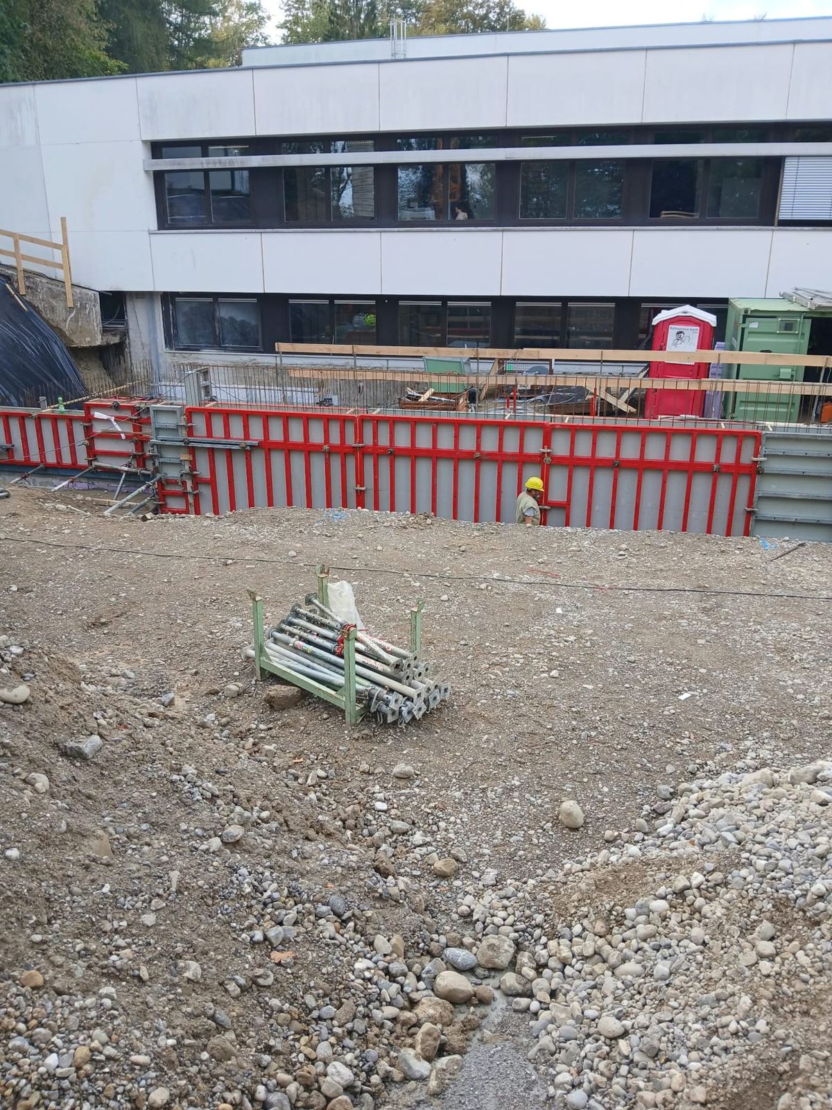 Gestellte Wandschalung vor dem bestehenden Schulgebäude